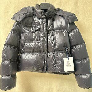 This Moncler black short down jacket features a puffy design for warmth and comf